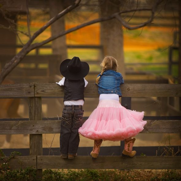 COWBOY AND COWGIRL ON FENCE