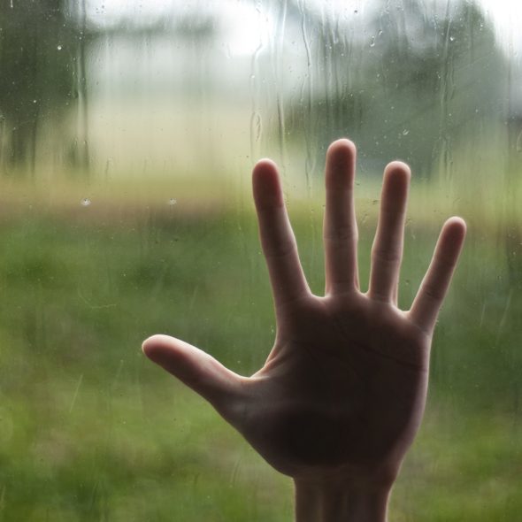 HAND ON WINDOW GLASS SMALLER